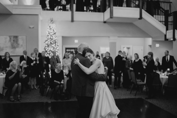 Bride laying her head on her dad's shoulder during their father daughter dance
