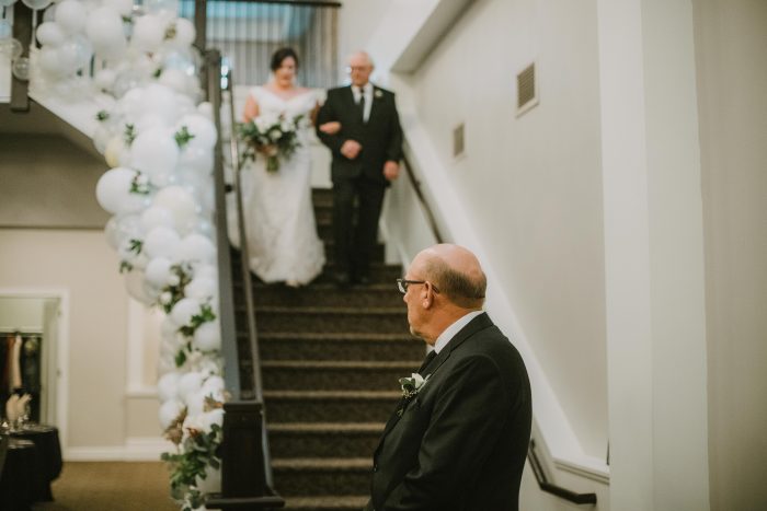 Bride and Father entering for ceremony down a grand staircase