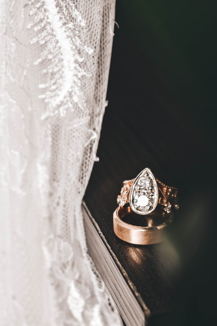 Vintage wedding ring sitting on grooms gold wedding band